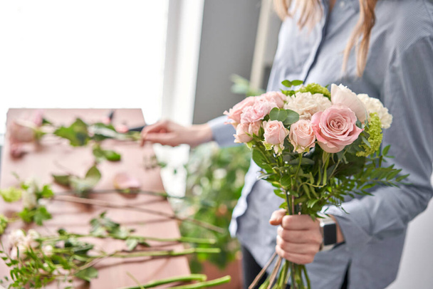 Floral shop concept . Florist woman creates flower arrangement. Beautiful bouquet of mixed flowers. Handsome fresh bunch. Flowers delivery. - Фото, изображение