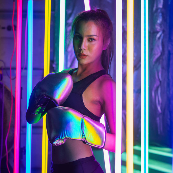 Красива 20-та азіатська жінка, пози зі срібним золотом Міттс-Ґловс. "Office Girl" тренується між "Modern multi color Fashion Neon Muay Thai Boxing Gym" і "that water splash" - Фото, зображення