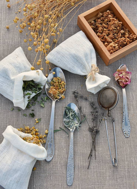 Dried herbs for healing herbal tea, linen bags, vintage spoons, flat lay. Herbalism, alternative medicine, natural home apothecary concept. - Photo, Image