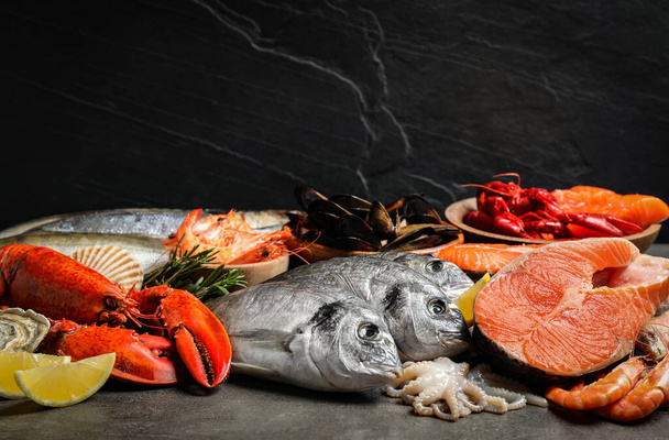 Peixe fresco e frutos do mar diferentes em mesa cinzenta
 - Foto, Imagem
