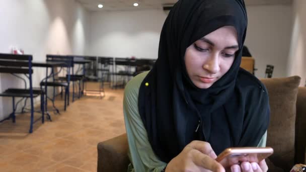 close-up van moslim vrouwen gebruik maken van smart phone in cafe - Video