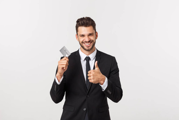Surprised, speechless and impressed handsome caucasian businessman in classic suit showing credit card, say wow, standing white background astonished - Valokuva, kuva