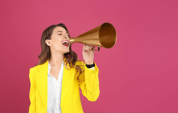 Young woman with megaphone on pink background - Foto, imagen