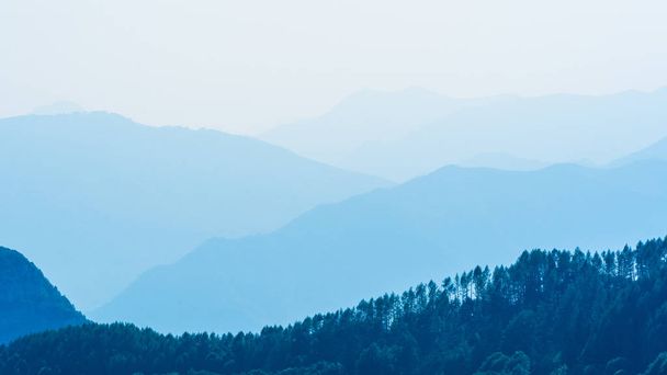 Голубой фон гор с некоторыми деревьями
 . - Фото, изображение