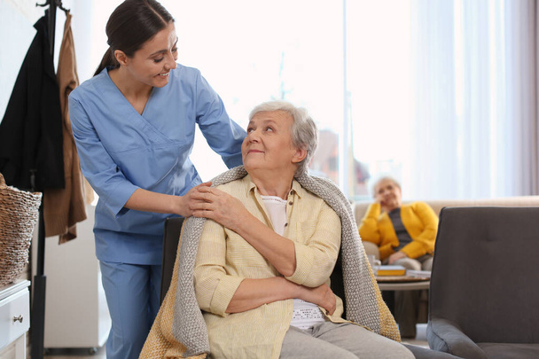Nurse taking care of elderly woman in geriatric hospice - Foto, Imagem