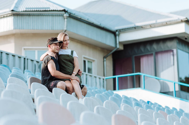 Młoda para przytula się na trybunach stadionu - Zdjęcie, obraz