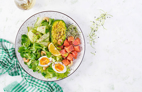 Alimentation cétogène petit déjeuner. Salade de saumon salé avec légumes verts, concombres, œufs et avocat. Keto / paléo déjeuner. Vue de dessus, vue aérienne
 - Photo, image