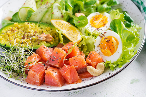 Ketogenic diet breakfast. Salt salmon salad with greens, cucumbers, eggs and avocado. Keto/paleo lunch. - Photo, Image