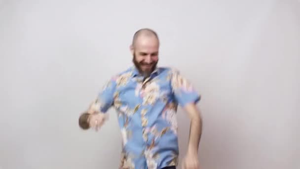 Happy bearded bald man having fun on white background. Joyful lucky tourist wearing hawaiian shirt. - Materiał filmowy, wideo