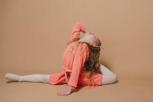 Beautiful little girl doing stretching exercises in studio  - Photo, Image
