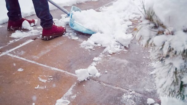 Молодой человек убирает снег с дороги
. - Фото, изображение