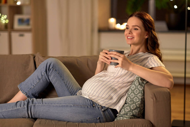 smiling pregnant woman drinking tea at home - Foto, imagen
