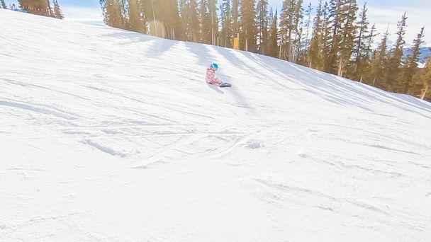 Κοριτσάκι που μαθαίνει πώς να κάνουν σκι κάτω από το λόφο στα αλπικά βουνά. - Φωτογραφία, εικόνα