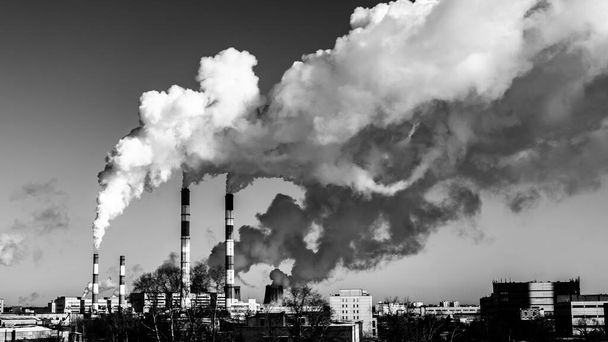 Zwart-wit industrielandschap, wervelende rookstralen van fabrieksschoorstenen vergiftigen de lucht met giftig afval. Vintage stadsgezicht met rook, luchtvervuiling. - Foto, afbeelding