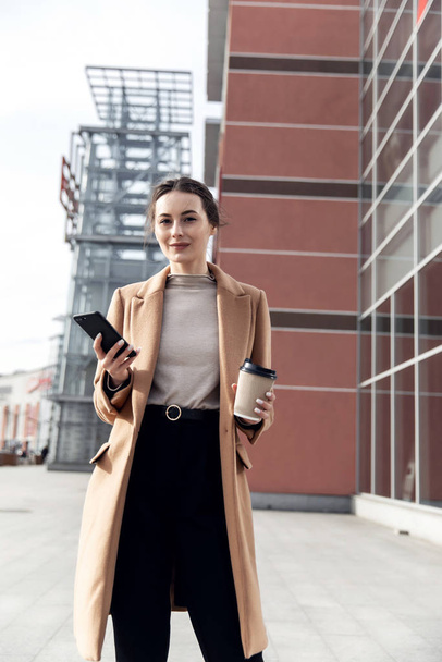 Young Businesswoman Smiling While Using a Mobile Phone - Foto, Imagen