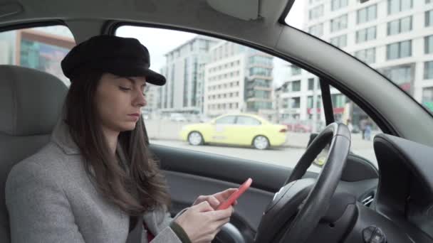 Bizneswoman za pomocą smartfona, wpisując na ekranie podczas oczekiwania kogoś w samochodzie - Materiał filmowy, wideo
