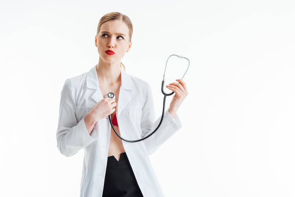 sexy nurse in white coat holding stethoscope isolated on white  - Фото, изображение