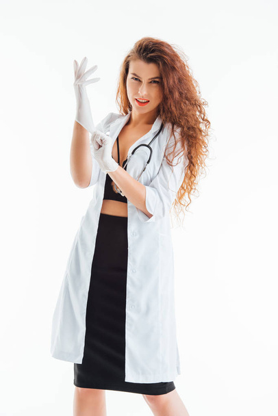 sexy nurse wearing latex gloves isolated on white  - 写真・画像