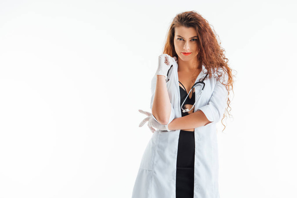 sexy nurse in latex gloves looking at camera isolated on white  - Fotó, kép