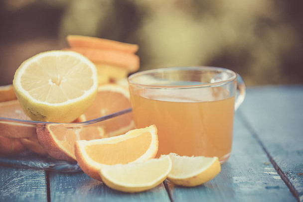 Morning fresh orange juice on blue wooden background - Foto, afbeelding