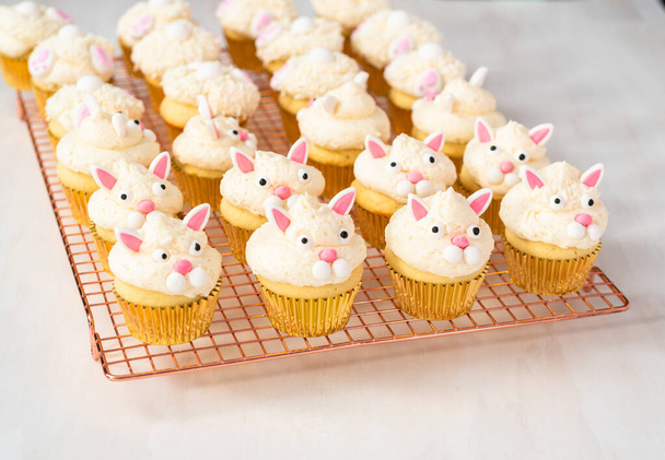 Paskalya için beyaz bir buttercream buzlanma ve tavşan kulakları ile vanilya cupcakes dekorasyon. - Fotoğraf, Görsel