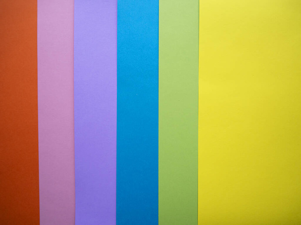 Different colors paper top view abstract background. Orange, pink, purple, blue, green and yellow cardboard paper sheets. - Photo, image