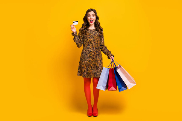 Full length body size view of her she nice attractive rich wealthy amazed cheerful wavy-haired girl holding in hand bag using bank card isolated on bright vivid shine vibrant yellow color background - Φωτογραφία, εικόνα