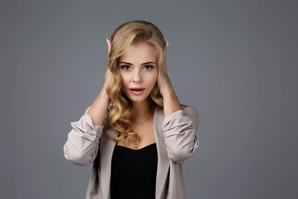 Portrait of young beautiful woman closes her ears with hand - Foto, Imagen