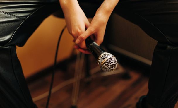 молодой музыкант с микрофоном в студии звукозаписи
 - Фото, изображение