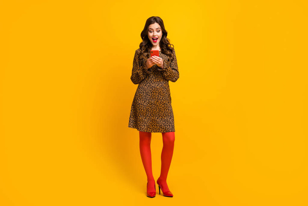 Full length body size view of her she nice attractive lovely cheerful cheery amazed wavy-haired girl using digital device app sale isolated over bright vivid shine vibrant yellow color background - Zdjęcie, obraz