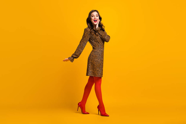 Full length body size view of her she nice-looking rich attractive lovely luxurious glad amazed cheerful cheery wavy-haired girl going isolated over bright vivid shine vibrant yellow color background - 写真・画像