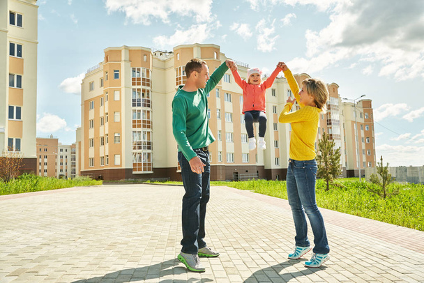 happy playing family outdoors. young parents with a baby for a walk in the summer. Mom, dad and child. - Valokuva, kuva