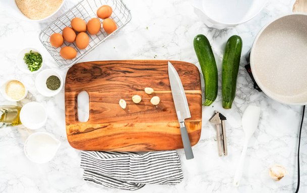 Flat lay. Cutting ingredients on a wood cutting board to make zucchini cakes. - Photo, Image