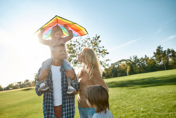 Love and care. Happy family playing a kite. Outdoor family weekend - Valokuva, kuva