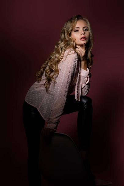 curly blonde woman in pink shirt - Valokuva, kuva