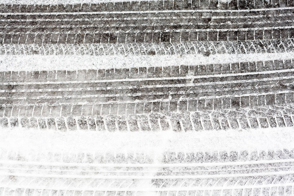 Pistas de ruedas en el camino de invierno cubierto de nieve. - Foto, Imagen