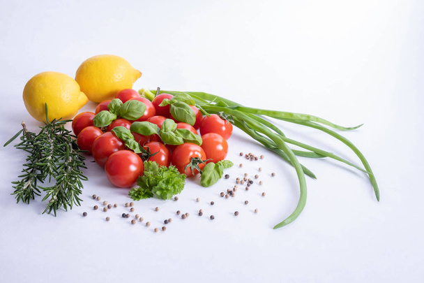 vegetables, green onions, lemons, basil and fresh tomatoes on the table on a white background - Foto, Imagen
