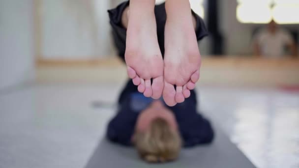 slow motion jonge onherkenbare man beoefenen van yoga in licht yoga klasse - Video