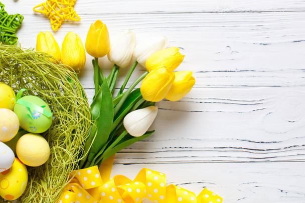 Happy Easter. Congratulatory easter background. Easter eggs and flowers. Background with copy space. Selective focus. Top view. - Zdjęcie, obraz