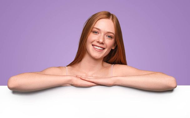 Happy redhead woman with empty white banner - Photo, Image