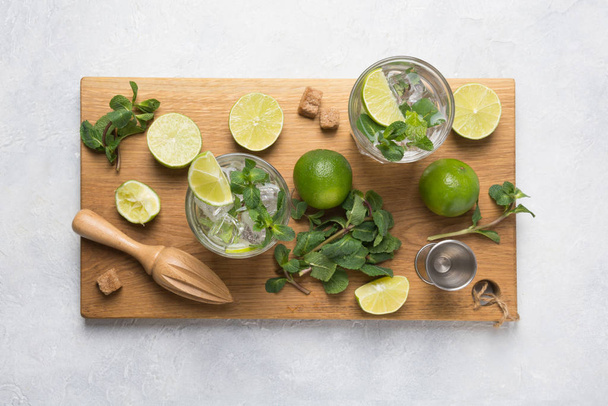 Mojito cocktail ingredients, lime, mint, jigger on cutting board. View from above. Horizontal format. - 写真・画像