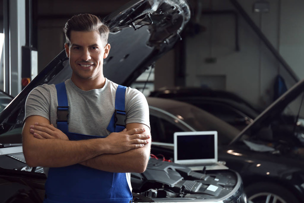 Mechanic near automobile in service center, space for text. Car diagnostic - Фото, зображення