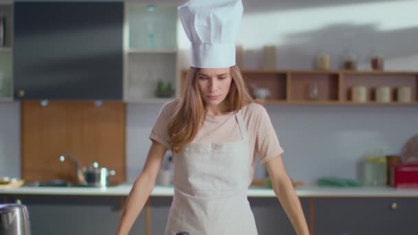 Šéfkuchař zkříží lžíce v rukou na kuchyni. Žena se usmívá do kamery - Záběry, video