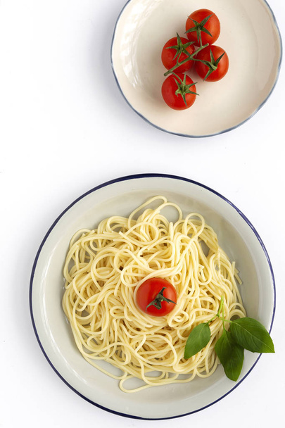 Spaghetti fatti in casa con salsa di pomodoro e basilico, visti dall'alto su sfondo bianco. Pasta italiana.Piatto
. - Foto, immagini