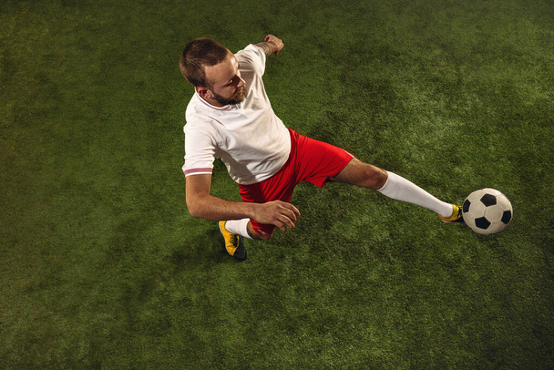 Top view of caucasian football or soccer player on green background of grass - Φωτογραφία, εικόνα