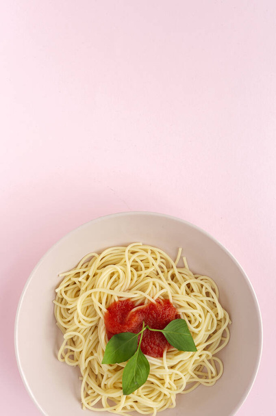 Homemade Spaghetti with tomato and basil sauce, seen from above on pink background. Italian pasta.Flat lay. - Fotoğraf, Görsel