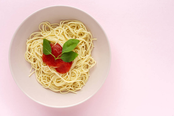 自家製スパゲティトマトソースとバジルソース,ピンクの背景に上から見た.イタリアのパスタフラットレイ. - 写真・画像