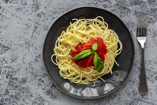 Homemade Spaghetti with tomato and basil sauce, seen from above on gray background. Italian pasta.Flat lay. - Foto, Bild