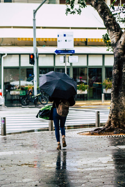 Tel Aviv Israel February 19, 2020 View of unidentified people walking in the streets of Tel Aviv during a raining day in winter - Foto, Imagem