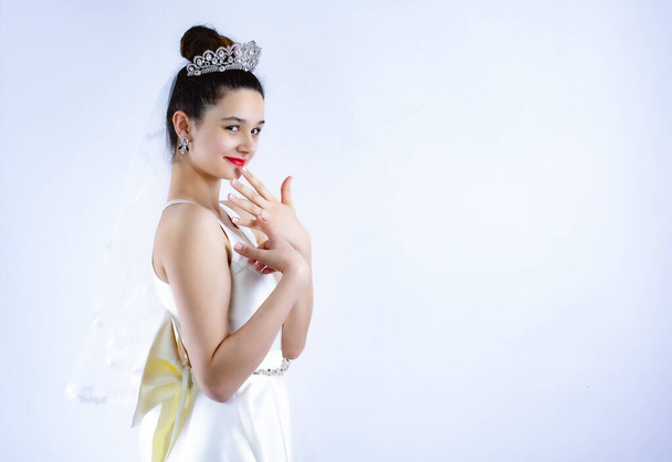 Ring on the finger of the bride, girl looks at the camera and shows a hand with a wedding ring. Tiara and hairstyle in bride. Close up portrait of Beautiful bride.Copy space - Φωτογραφία, εικόνα
